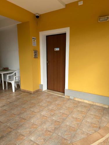 a yellow wall with a door and a table at Villa Maria in Lamezia Terme