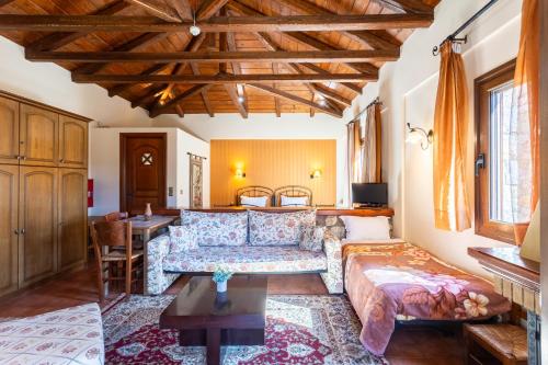 a living room with a couch and a table at Pleiades Studios All Season Gems - Korinthos Stone Retreats in Kalianoi