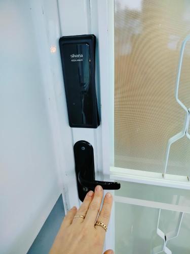 a person holding a remote control in a window at Pernoitar in São José