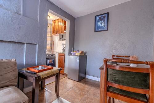 a kitchen with a table and a refrigerator at Simba The lion Apartment Mawanda Road in Kampala