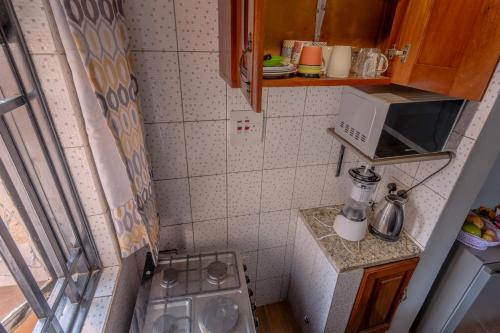 a small kitchen with a stove and a microwave at Simba The lion Apartment Mawanda Road in Kampala