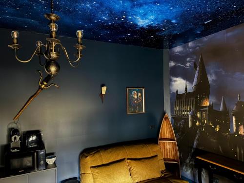 - une chambre avec un lit et une peinture d'un château dans l'établissement La traversée des sorciers, à Reims