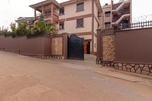 a house with a black gate on a street at Simba The lion Apartment Mawanda Road in Kampala