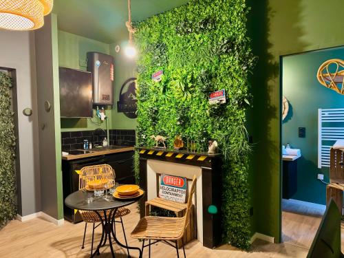 - une cuisine avec un mur vert, une table et des chaises dans l'établissement Jurassique Reims, à Reims