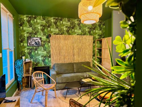 - un salon avec un canapé et un mur vert dans l'établissement Jurassique Reims, à Reims