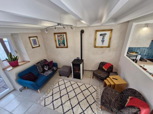 un salon avec un canapé bleu et des chaises dans l'établissement Cozy House with Garden & Hot Tub, à Jarnages