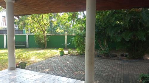 an outdoor patio with a pavilion with trees and plants at Milan Restinn in Polgahawila