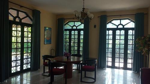 a dining room with a table and chairs and windows at Milan Restinn in Polgahawila