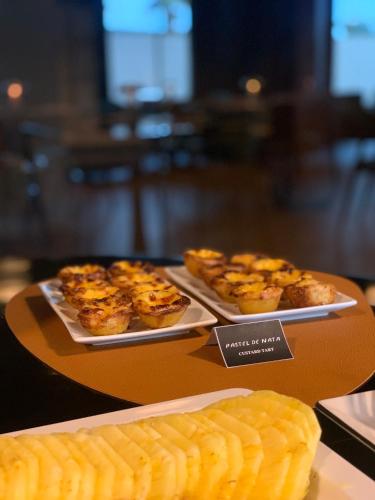 two trays of food sitting on a table at Hotel Leiriartem by Grupo Quinta dos Lagos in Leiria