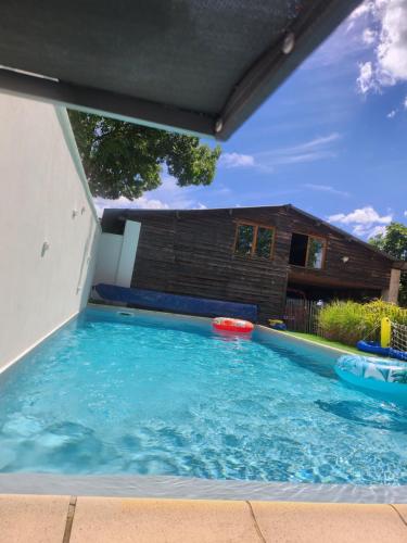 - une grande piscine dans une cour avec une maison dans l'établissement La maisonnette du marais, à Amuré