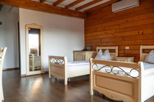 a bedroom with two beds and a wooden wall at LifeHarbour Limanu in Limanu