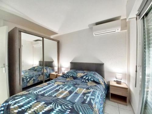 une chambre avec un lit et un grand miroir dans l'établissement Appartement T2 Port Fréjus - WIFI CLIM, à Fréjus