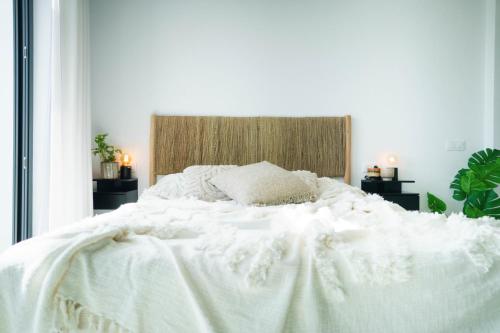 a white bed with a white comforter and pillows at Emerald Suite Plaza in Corralejo