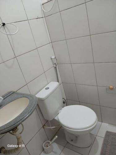 a white bathroom with a toilet and a sink at Cantinho da bel in Maragogi