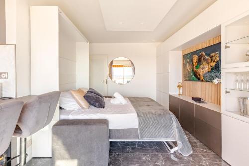 une chambre avec un lit, un canapé et un miroir dans l'établissement Vue mer et montagne panoramique, à Nice