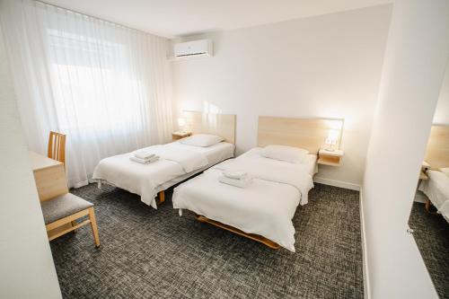 a hotel room with three beds in it at Hotel Tomas in Šiauliai