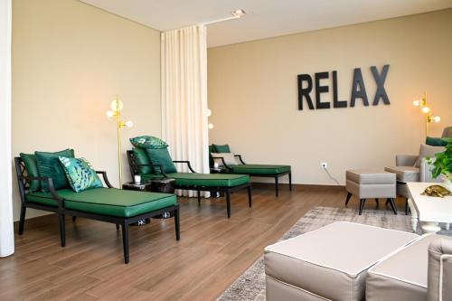 a waiting room with green chairs and a relax sign on the wall at Casas Novas Countryside Hotel Spa & Events in Chaves