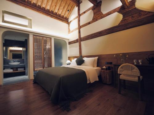 una camera da letto con un letto grande e un bagno di Leisure Courtyard Seascape Designer Hotel a Dali