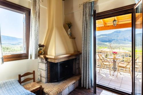 a living room with a fireplace and a balcony at Pleiades Studios All Season Gems - Korinthos Stone Retreats in Kalianoi