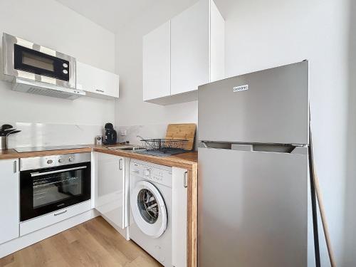 une cuisine avec un réfrigérateur et une machine à laver dans l'établissement Le Petit Sud - Appartement Proche des Halles - Wifi, à Narbonne