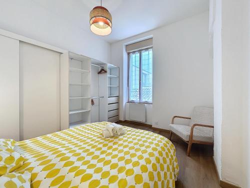 une chambre avec un lit jaune et blanc et une fenêtre dans l'établissement Le Petit Sud - Appartement Proche des Halles - Wifi, à Narbonne