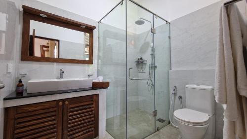 a bathroom with a toilet and a sink and a shower at Villa Arana Bentota in Bentota