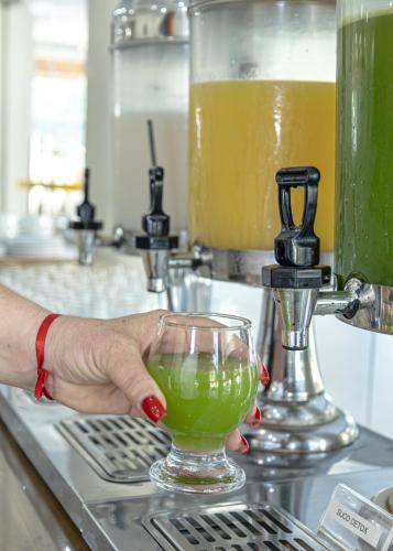 a person is holding a drink in a glass at Ramada by Wyndham Porto Seguro Praia in Porto Seguro