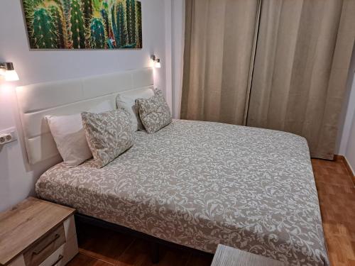 a small bed in a small room with a table at I love you 203 in Mogán