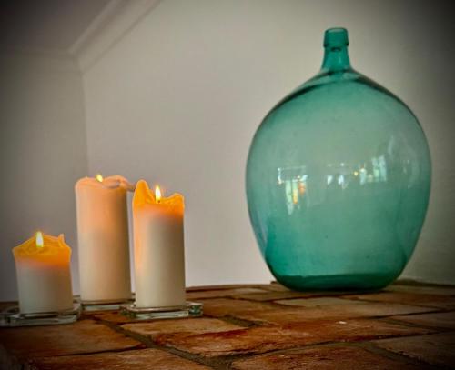 three candles on a table next to a glass vase at Neu! ULENHUUS Mecklenburgische Schweiz Laage Güstrow Rostock Port Bed and Breakfast - Pension -Ferienhaus - Familienurlaube bis 10 Personen in Kuhs