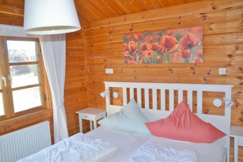 a bedroom with a white bed with red pillows at Ferienhaus Neckar 58 in Hayingen
