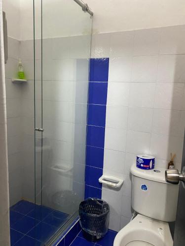 a bathroom with a toilet and a glass shower at Hotel Casa Corleone in Garzón