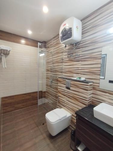 a bathroom with a toilet and a sink and a shower at The SM Hotel By RMR Hotels in New Delhi