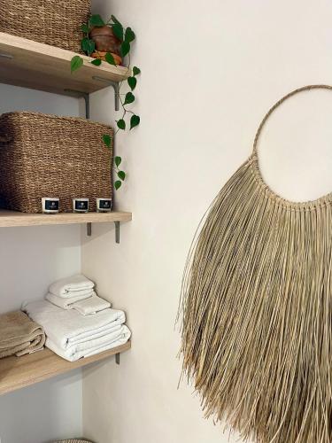 une étagère avec des paniers en osier et un miroir mural dans l'établissement Villa Évasion Saint-Cyrienne, à Saint-Cyr-sur-Mer