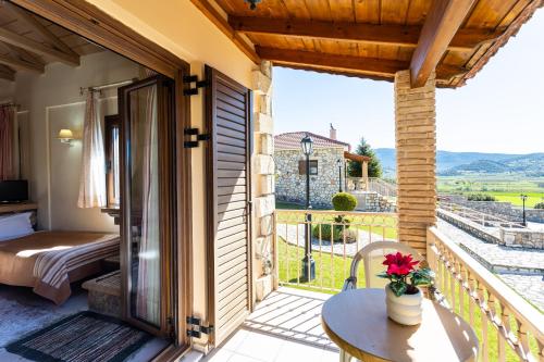 a room with a balcony with a bed and a table at Pleiades Studios All Season Gems - Korinthos Stone Retreats in Kalianoi