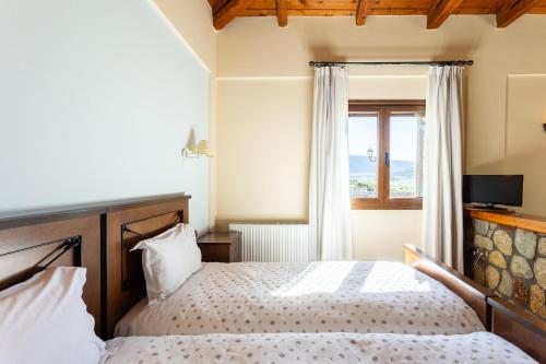 a bedroom with a bed and a window at Pleiades Studios All Season Gems - Korinthos Stone Retreats in Kalianoi