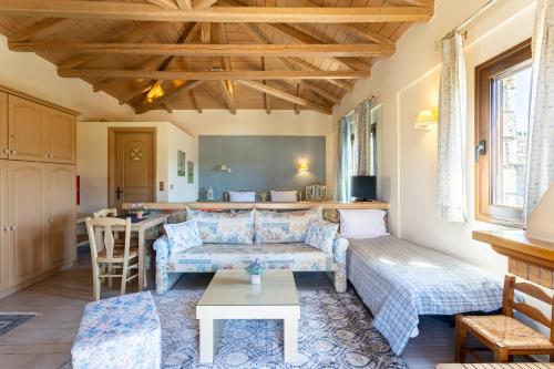 a living room with a couch and a table at Pleiades Studios All Season Gems - Korinthos Stone Retreats in Kalianoi