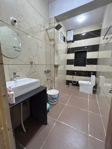 a bathroom with a sink and a toilet at MEENAKSHI GUEST Inn in Hampi