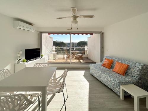 un salon avec un canapé et une table dans l'établissement Pacific - studio avec terrasse parking et clim, à La Grande Motte