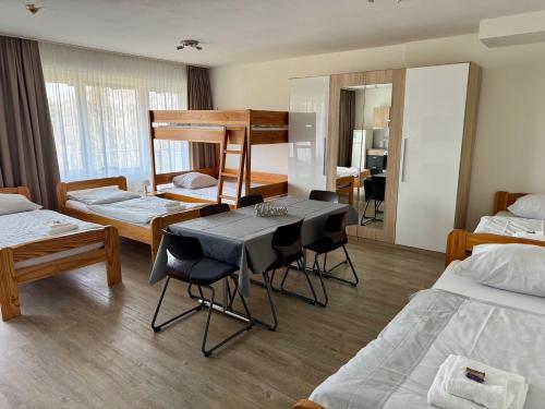 a room with two beds and a table and chairs at Gästehaus Haßloch/Pfalz in Haßloch