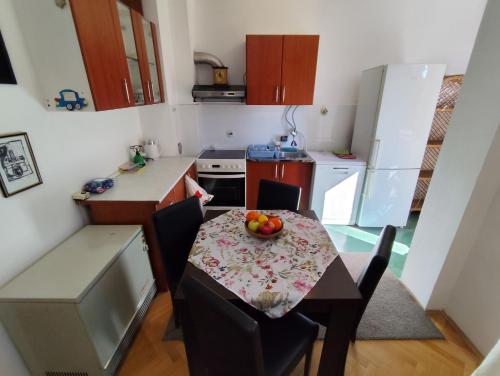 una pequeña cocina con una mesa con un bol de fruta. en HarmonyHome, en Podgorica