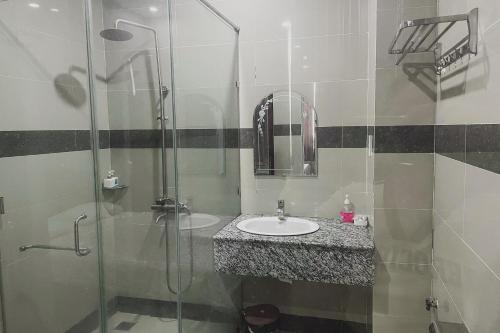 a bathroom with a sink and a glass shower at Sky Hotel in Bien Hoa