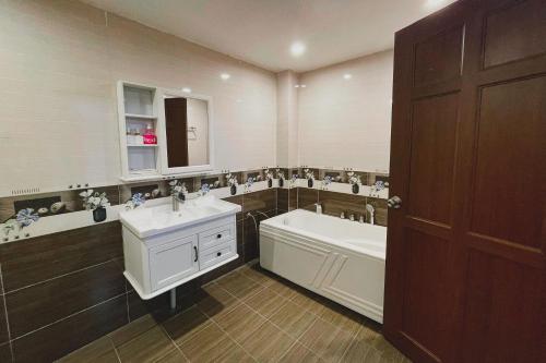a bathroom with a tub and a sink and a bath tub at Sky Hotel in Bien Hoa