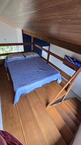 a small bed in a room with a wooden floor at Residencial Mineiro - Studio in Itapoa