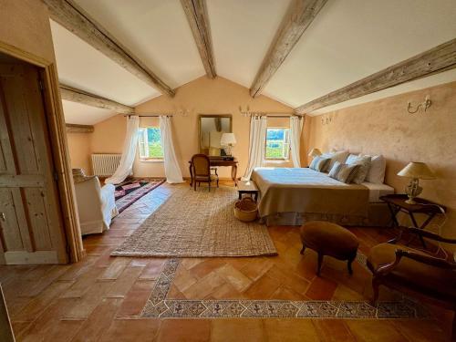 une chambre avec un lit et une table dedans dans l'établissement Mas de Saint Pierre, à Visan