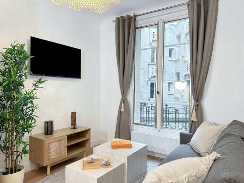 un salon avec un canapé et une grande fenêtre dans l'établissement Brand new flat near Eiffel Tower, à Paris