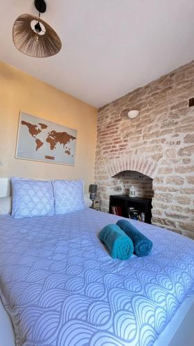 une chambre avec un grand lit avec un mur de briques dans l'établissement Le Clos des Perrières, à Dijon