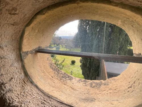 a circular window in a stone wall with a view at Maison de la Source in Génis