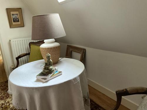 a table with a lamp and books on it at Maison de la Source in Génis