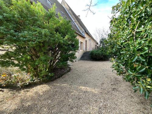 a path next to a building with a bush at Maison de la Source in Génis