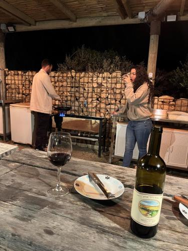 a woman drinking wine at a table with a bottle of wine at Carmey Avdat Farm in Midreshet Ben Gurion